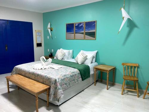 1 dormitorio con cama y pared azul en Pousada Vila de Charme, en Barreirinhas