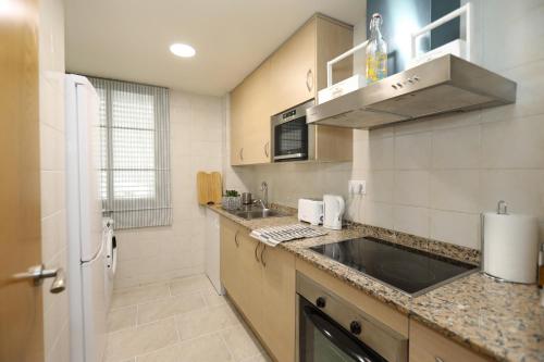 a kitchen with a sink and a refrigerator at Mazi Apartments Martinet in Mataró