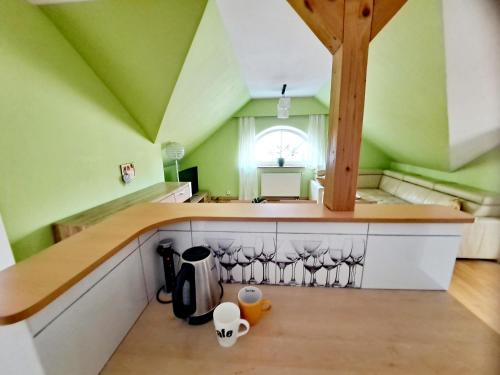 a kitchen with green walls and a wooden counter top at Apartament Centrum - Giżycko in Giżycko