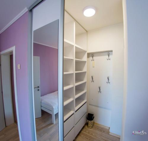 a walk in closet with a mirror in a room at Central Loft in Mostar