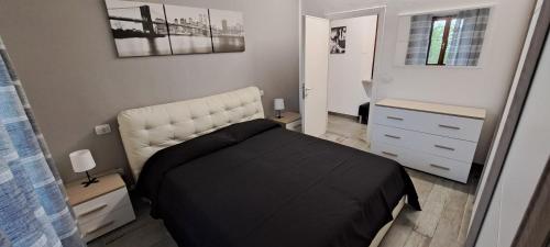 een slaapkamer met een zwart bed met een wit hoofdeinde bij Firenzuola Loft in Volterra