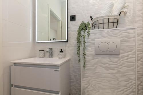 bagno bianco con lavandino e specchio di Pansion Gaspar a Biograd na Moru