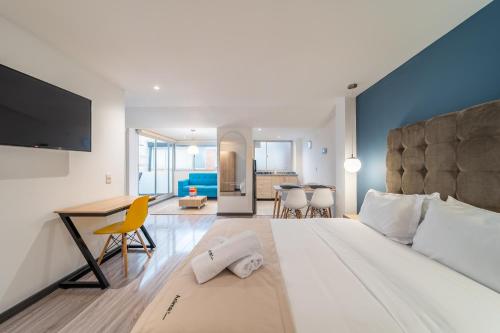 um quarto com uma cama grande, uma secretária e uma cozinha em Anima 64 em Bogotá