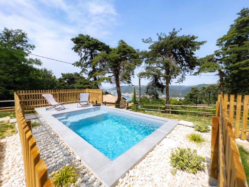 una piscina con 2 sillas en un patio en -LA BOOA- Maison écologique 65m2 -Piscine privée- Ardèche GESTLOC, en Ozon