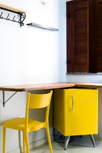 a yellow desk with a yellow chair next to it at Pousada Vila de Charme in Barreirinhas