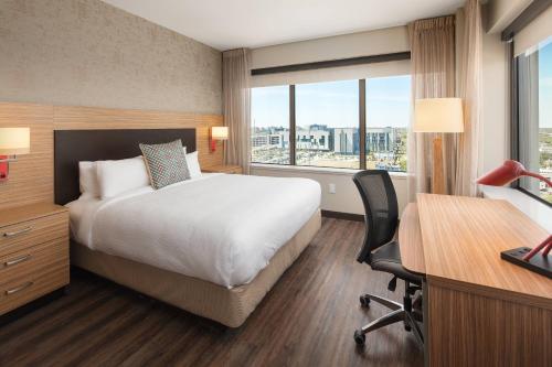 ニューオーリンズにあるTownePlace Suites by Marriott New Orleans Downtown/Canal Streetのベッド、デスク、窓が備わるホテルルームです。
