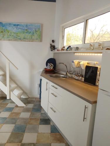 uma cozinha com um lavatório e uma bancada em Minha casa em Olhão