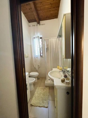 a bathroom with a sink and a toilet and a mirror at Casa Nennella con Parcheggio Auto gratuito in Loco in Naples