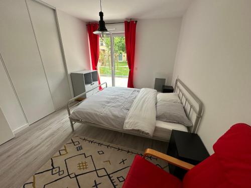 1 dormitorio con 1 cama y una ventana con cortinas rojas en L'Aumonerie en Angers