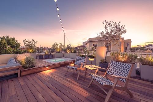 a rooftop deck with chairs and a hot tub at Moon And Stars Athens in Athens
