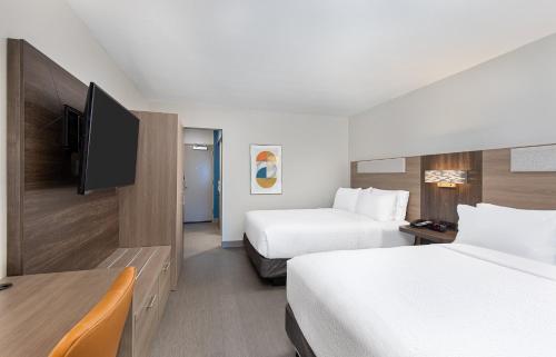 a hotel room with two beds and a flat screen tv at Holiday Inn Express Atlanta Airport - North, an IHG Hotel in Atlanta