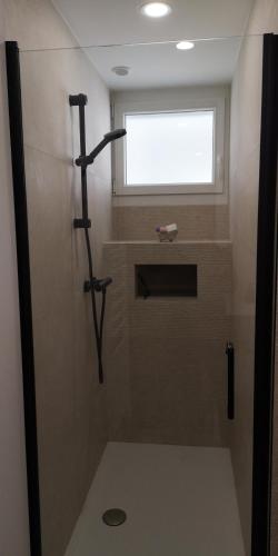 La salle de bains est pourvue d'une douche et d'une fenêtre. dans l'établissement FACE A LA MER, à Cassis