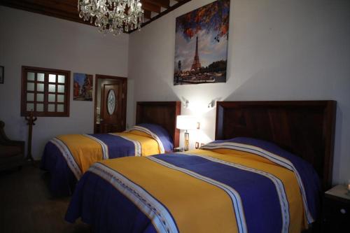 a bedroom with three beds with yellow and blue at La Casa Baez in Pátzcuaro