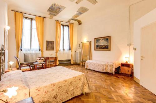 a hotel room with two beds and a desk at Albergo San Giovanni in Florence