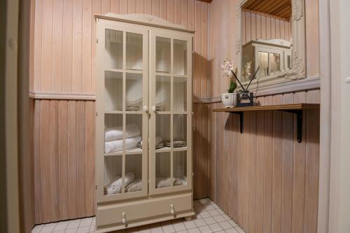 un armario blanco con puertas de cristal en una habitación en Kooli Apartment, en Pärnu