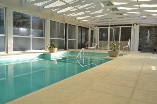 a swimming pool with chairs in a building at Apart IMEB spa & wellness in Río Cuarto
