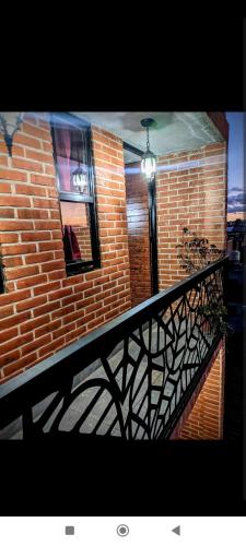 un balcone di un edificio in mattoni con ringhiera nera di Departamento Xolotl (Dios guía y del fuego) a Cholula
