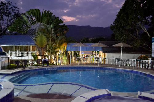 a large swimming pool with chairs and umbrellas at Villeta Boutique Hotel Spa in Villeta