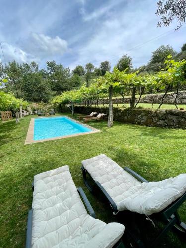 a swimming pool with two lounge chairs and a swimming pool at Casa de Morão in Viana do Castelo