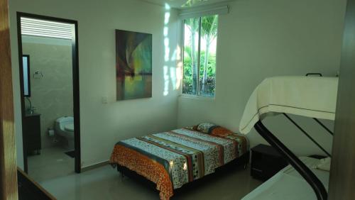 Habitación pequeña con cama y baño. en Condominio Villa Esperanza, en Flandes