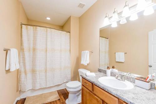a bathroom with a sink and a toilet and a mirror at Luxury Apt Westheimer/Galleria in Houston