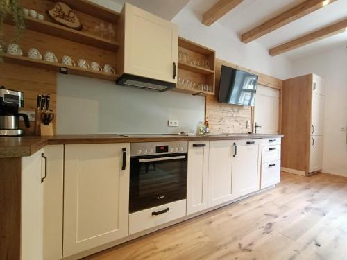 a kitchen with white cabinets and an oven at Appartements Bergheim in Hirschbichl