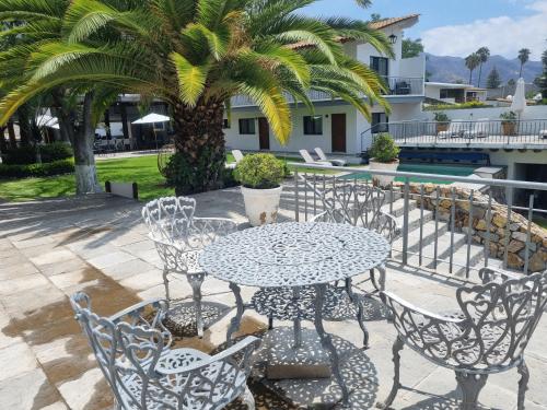 a patio with a table and chairs and a palm tree at Hotel La Ribereña in Ajijic