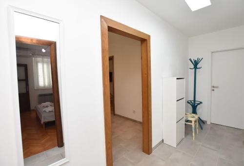 a hallway with a mirror and a door to a room at Apartments Dragica in Primošten