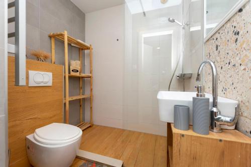 a bathroom with a white toilet and a sink at Apartment Zdravka in Omiš