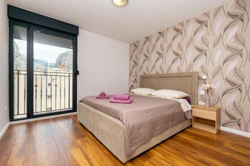 a bedroom with a bed and a large window at Apartment Zdravka in Omiš