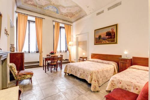 una camera d'albergo con due letti e un tavolo di Albergo San Giovanni a Firenze