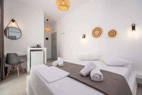 a white bedroom with two white towels on a bed at ALTHEA PAROS in Naousa