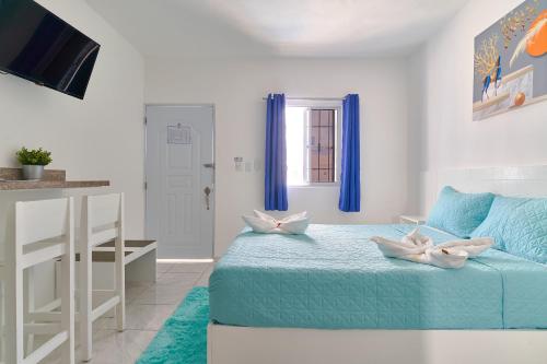 a bedroom with a bed with blue sheets and a window at Costa Love Hotel Aeropuerto in Punta Cana