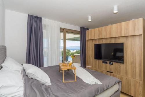 a bedroom with a bed with a tv and a table at Villa El Viento in Šmrika