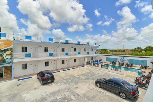 een gebouw met twee auto's geparkeerd op een parkeerplaats bij Costa Love Aparta Hotel in Punta Cana