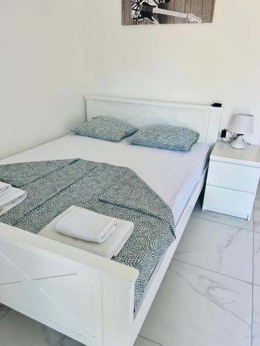 a white bed with two pillows on top of it at Apartments Mia Patria in Ulcinj