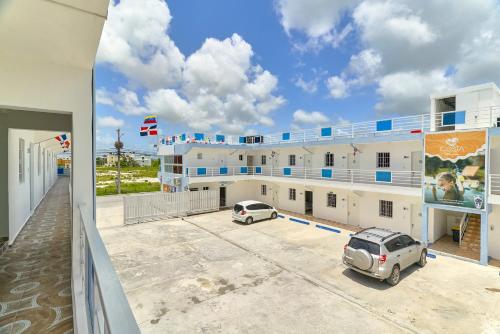 ein Gebäude mit zwei Autos auf einem Parkplatz in der Unterkunft Costa Love Aparta Hotel in Punta Cana