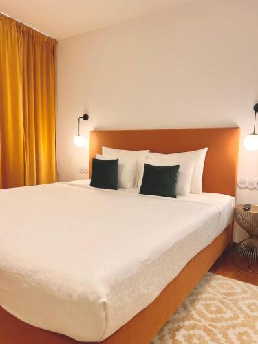 a bedroom with a large white bed with two pillows at 145 Townhouse in Ílhavo