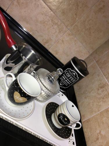 a counter top with plates and cups on it at Apartman San Remo Brcko in Brčko