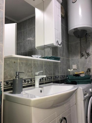 a bathroom with a white sink and white cabinets at Apartman San Remo Brcko in Brčko