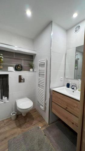 une salle de bain blanche avec des toilettes et un lavabo dans l'établissement Location estival parfaite : Studio à 50 mètres de la plage, offrant une magnifique vue mer, à Fréjus