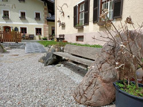 a wooden bench sitting in front of a building at Appartements Bergheim in Hirschbichl