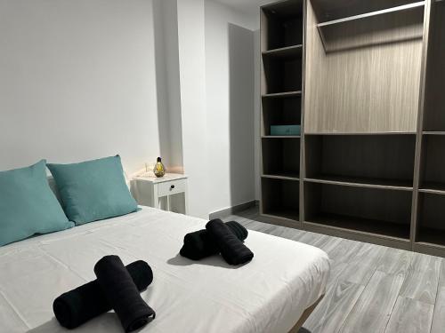 a bedroom with a bed with black towels on it at Estadio playa in Almería