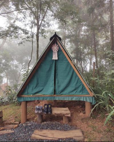Tienda con mesa de picnic en el bosque en Aqui no Camping, en Brumadinho