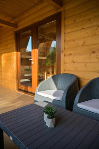 a table and two chairs on a porch with a table and a window at Bungalow Jajce 1 in Jezero