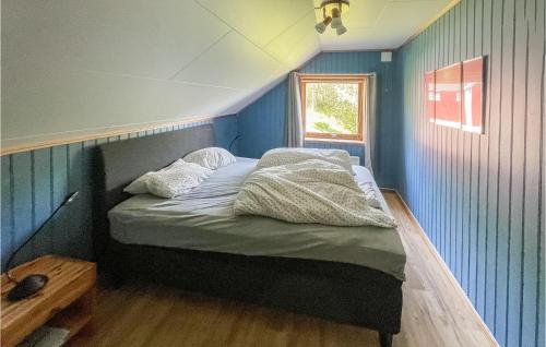 a bedroom with a bed with blue walls and a window at Cozy Home In Bogen I Ofoten in Bogen