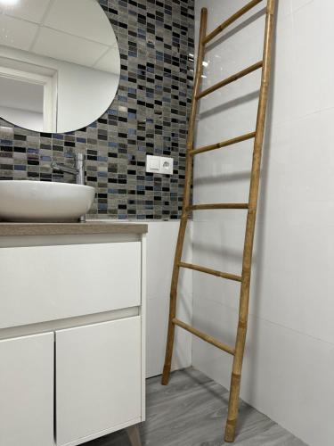 een ladder in een badkamer met een wastafel en een spiegel bij Estadio playa in Almería