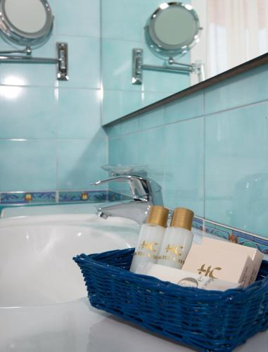 a basket on a bathroom counter next to a bath tub at Hotel Capri Bardolino 3S in Bardolino