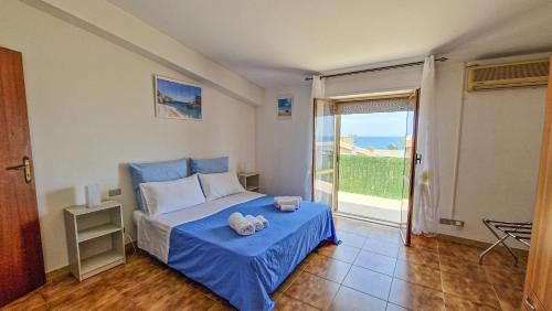 a bedroom with a blue bed and a balcony at Blue Horizon Calabria - Seaside Apartment 120m to the Beach - Air conditioning - Wi-Fi - View - Free Parking in Santa Caterina Dello Ionio Marina
