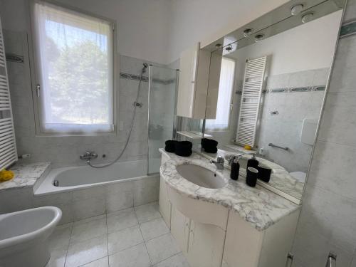 een witte badkamer met een wastafel, een bad en een wastafel bij Casa Tullo in San Costanzo